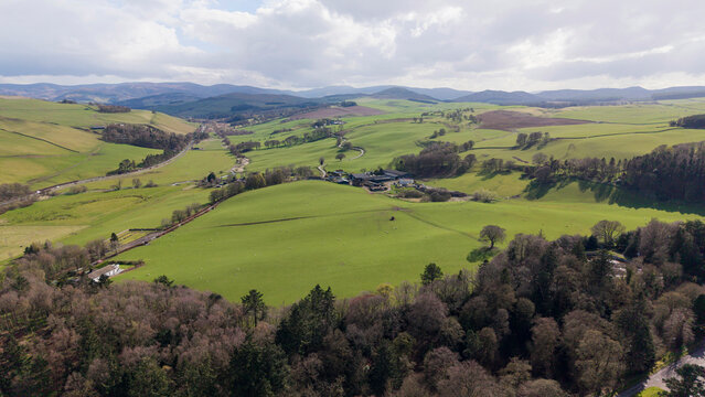 A serene and sweeping view of rolling green hills and the traditional Scottish countryside. The photograph captures the natural beauty of Scotland&rsquo;s iconic landscape.