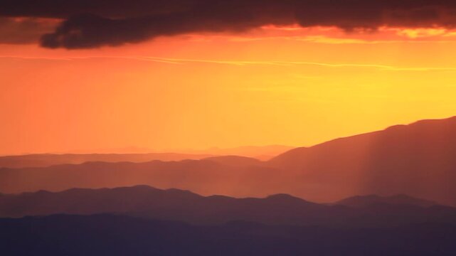 大黒森から望む早池峰山と折爪岳などの山並みと朝の光芒