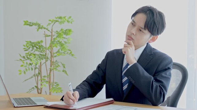 勉強・メモをするスーツを着た男性