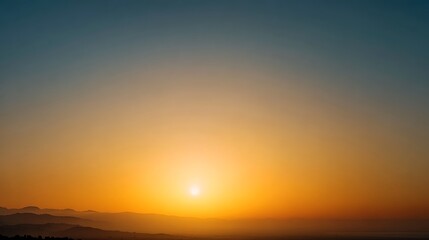 Obraz premium Sunset over mountains with a vibrant orange and blue sky