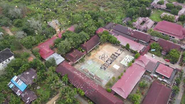 Drone aerial school yard students formation event in rural area