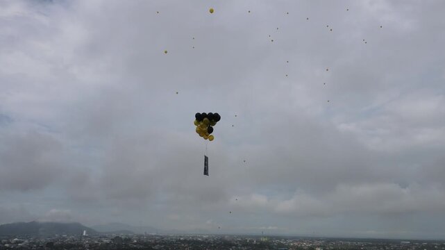 Drone aerial balloons release flying over city cloudy sky event