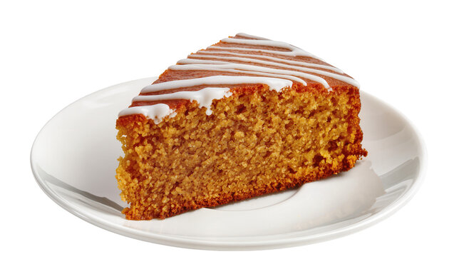 Brown spiced cake slice with white glaze on ceramic plate