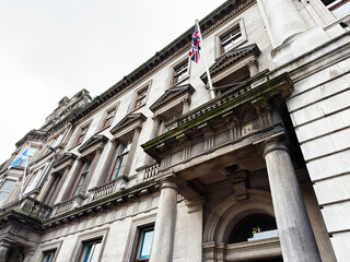 Naklejka premium Historic stone facade with classical columns and Union flag on a Georgian civic building in central Edinburgh, Scotland, UK