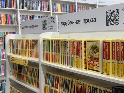 Moscow, Russia - April 14, 2026: Bookshelves displaying foreign literature by Erich Maria Remarque in a bookstore with organized sections and QR codes