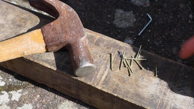 Video of nails and hammering it into wood.