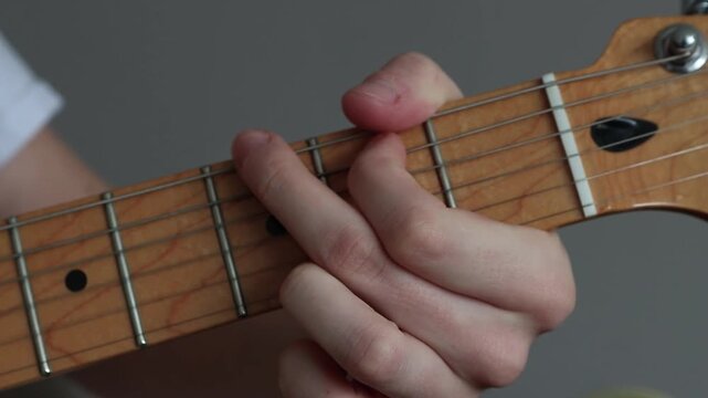 Close up of a hand changing through chords on a guitar neck