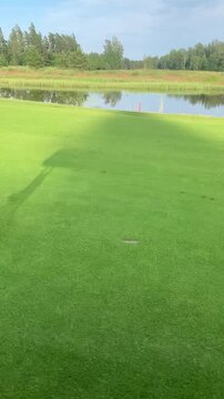 Golf cart shadow moving across sunny green landscape