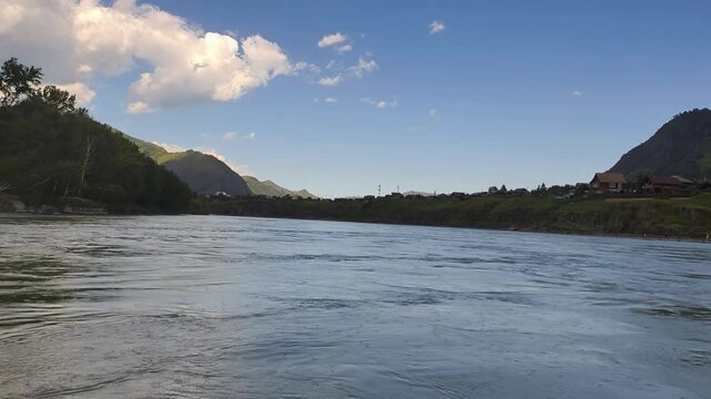 A motorboat ride along mountain river. Slow motion of speedboating on Altai river Katun in rainy day