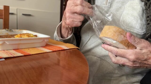 Senior woman struggling to unpack the bread packing.