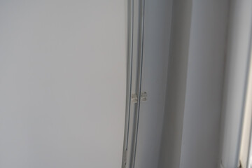 Close-up view of a sleek and contemporary ceiling cornice featuring clean lines and subtle detailing. This minimalist design adds a touch of elegance to modern interior spaces. © magpie