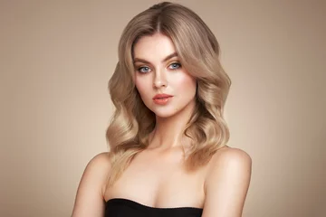 A beautiful young woman with shiny wavy blonde hair. Model with healthy skin, close up portrait. Cosmetology, beauty and spa © Oleg Gekman