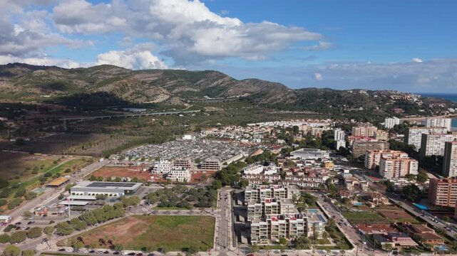 Benicassim,Castellon, Spain slow forward drone footage towards the Desert de les Palmes mountains with the elevated A7 motorway in front showing the town on bright sunny day