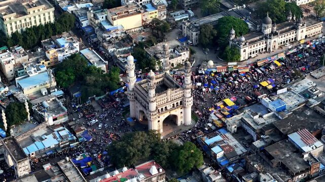 Immersive drone 360&deg; perspective of Charminar showcasing vibrant street life, packed marketplaces, historic structures, and dynamic traffic forming a circular urban rhythm.