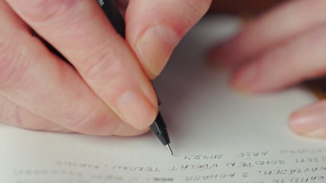 Detailed shot of a person writing coded notes in a diary, implying secrecy, espionage, or hidden communication. Ideal for thriller, investigation, or conspiracy-driven narratives.