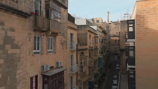 Narrow Historic Street In Valletta, Malta, Lined With Limestone Buildings, City Of Birgu, Three cities Revealed. ascending drone