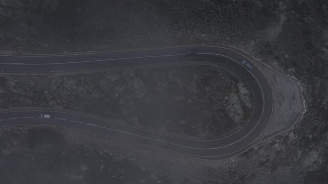EN339 hairpin near Torre in Serra da Estrela Seia municipality Guarda district Centro region Portugal showing engineered switchback curve with vehicles as drone descends through mist to clear view