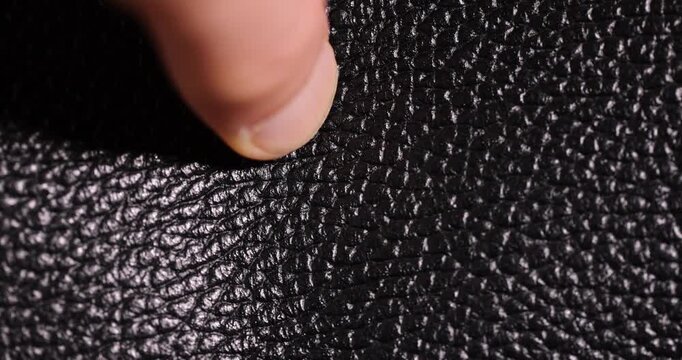 details of a natural black leather bag after prolonged use, details and pieces of natural leather used for the production of items, shadow