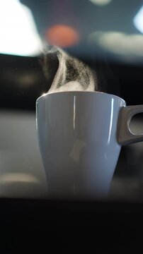 Dense billowing cloud of steam rising from a gray ceramic mug captured in slow motion, blurred bokeh background with red and white light spot, dynamic motion detail