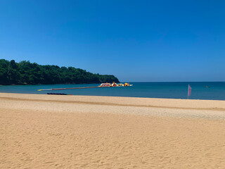 Obraz premium Beach view of the sand and ocean with inflatable island