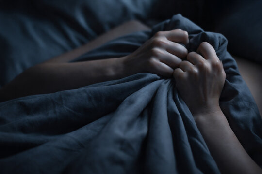 woman pulling gray blanket over body while lying in bed. Person suffering from depression or anxiety in bedroom. Concept of sleep disorder, loneliness, insomnia and inner emotional stress
