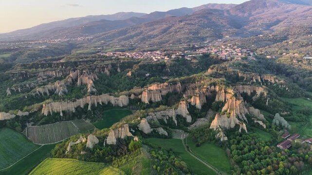 Aerial view of the Balze rock formations with unique clay pinnacles and lush green valleys at sunset in Reggello, Tuscany, Italy.