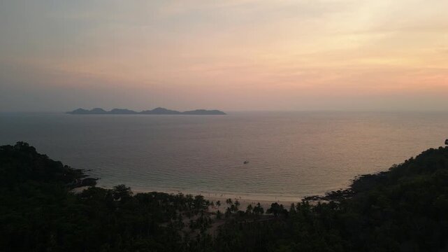Koh Mook, Thailand: Cinematic orbit aerial drone footage of the sunset over the famous Farang beach in the Koh Muk with the Kradan island in the background in Thailand. 
