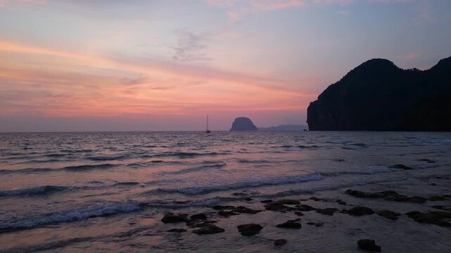 Koh Muk, Thailand: Slow motion aerial footage of waves breaking in Charlie beach in Koh Muk, South Thailand. Taken with forward motion showing dramatic sunset