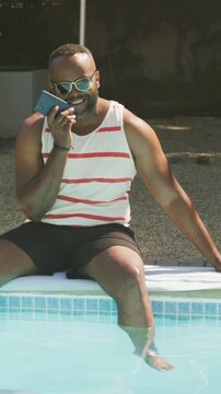 Man receiving call chatting and dipping foot in pool tech bubbles morphing into ripples from phone