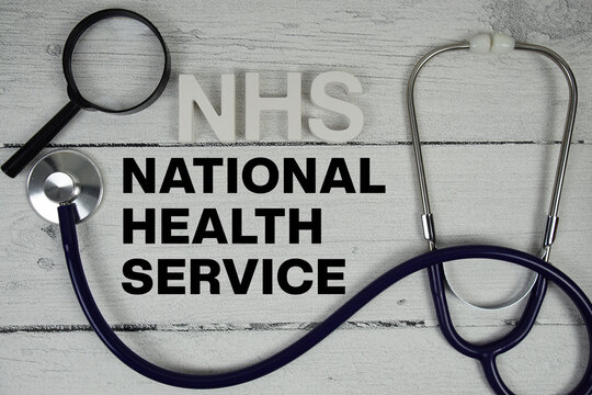 NHS National Health Service text with Stethoscope on wooden background