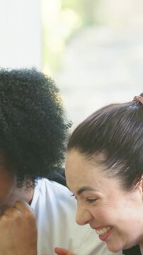 Vertical video: Reacting pal on right yelling at phone alert on couch, watch visible removing coat