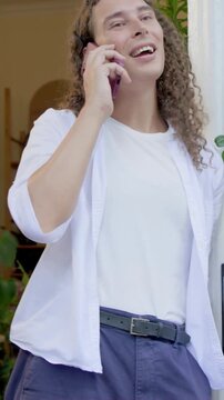 Vertical video: Scrolling adult then answering incoming call in doorway with pink phone and plants