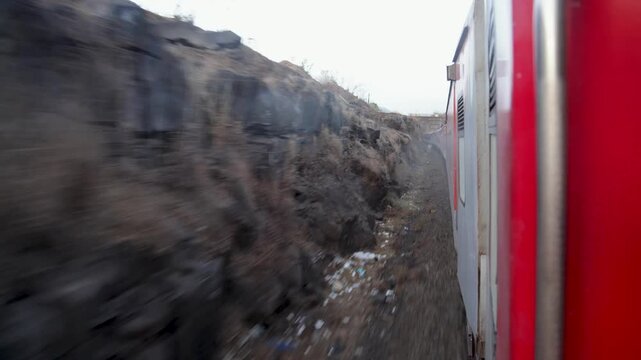passenger train journey with motion blur on narrow track at konkan railway hills