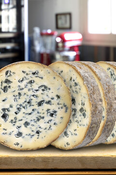 Slices of Fourme d'Ambert cheese on a chopping board in a kitchen