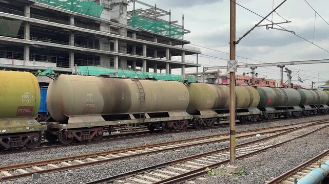 freight train with oil tanker wagons parked on railway line in industrial area india