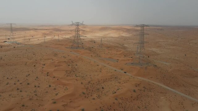 A drone view of High-voltage electric poles in the desert in UAE