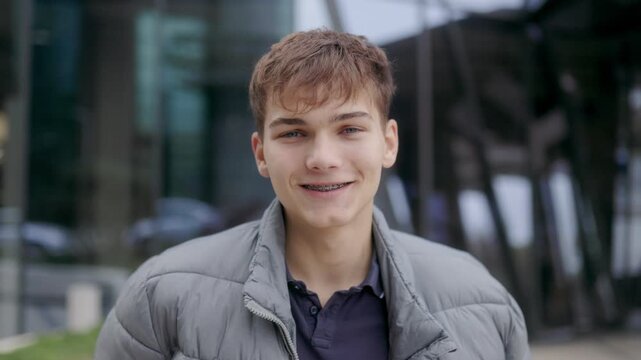 Close up portrait of one young man with braces smiling in modern style.
