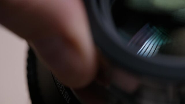Extreme close-up of a PL bayonet mount being carefully placed onto a cinema lens. Only a quarter of the mount visible, revealing fine metal details and precision engineering.