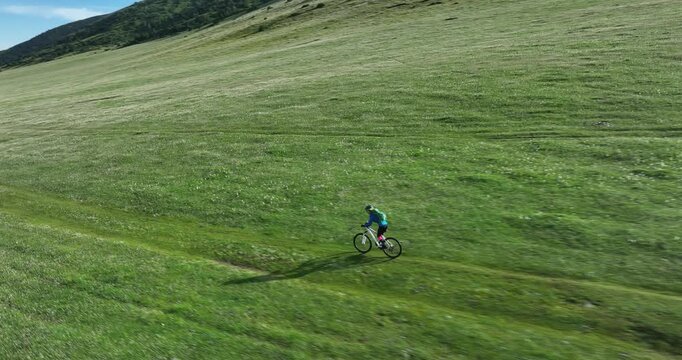 Aerial footage of woman riding mountain bike on beautiful forest mountain trail