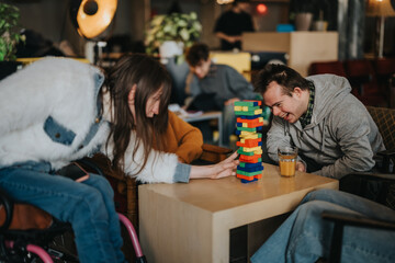 Students with disabilities and friends laugh and play a colorful stacking block game at a table. A group of young people enjoy a relaxed, inclusive game session in a casual cafe setting. © qunica.com