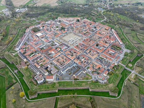 Aerial view of the star-shaped fortress city with its symmetrical layout and red-tiled roofs surrounded by lush green moats, Neuf-Brisach, Grand Est, France.