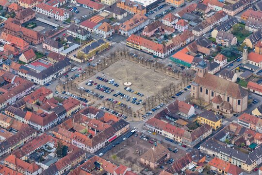Aerial view of the meticulously planned grid layout and central square, with buildings adorned with red tile roofs creating a warm contrast against the pale sky, Neuf-Brisach, Grand Est, France.
