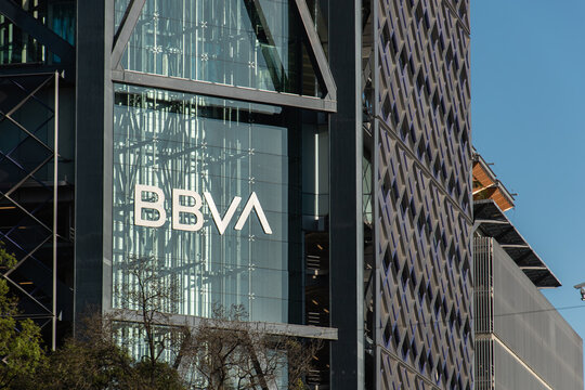 Mexico City, MEXICO - Jan 18 2025 : Street-level view of Torre BBVA Bancomer's glass curtain wall displaying the logo, alongside an adjacent building's textured concrete facade.