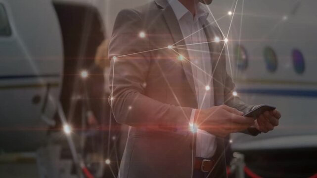 Man in suit tapping phone by private jet, activating glowing network overlay and confirming flight