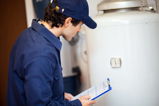 Professional technician inspecting water heater