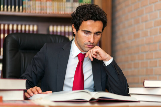 Thoughtful businessman analyzing documents in library