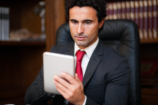 Professional businessman using tablet in office library