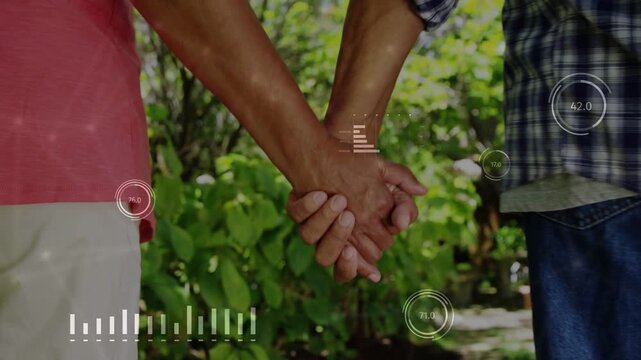 Vertical video: Senior couple holding hands on path, grip sending health HUD bars showing vitals