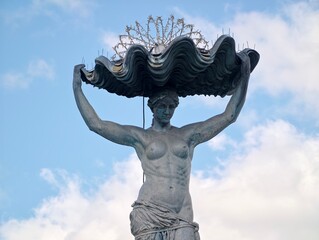 Decorative stone sculpture. Artistic stone fountain embodying shell motif and peaceful harbor scenery © Vladimir