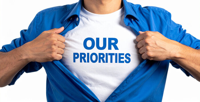 Our priorities - Ein Mann öffnet sein Hemd und zeigt sein TShirt